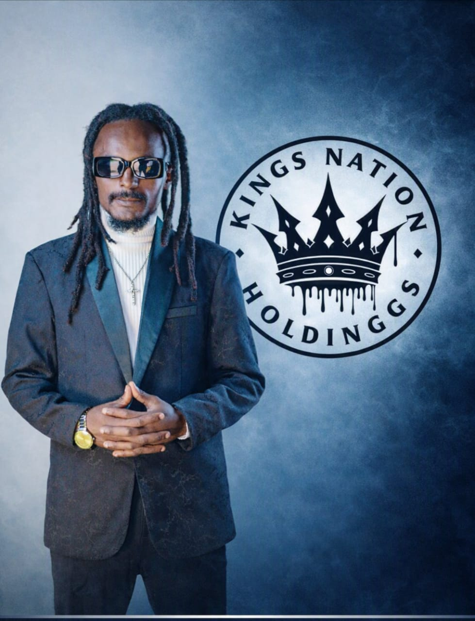 Founder & C.E.O of Kings Nation Holdings standing beside the Kings Nation Holdings crown emblem