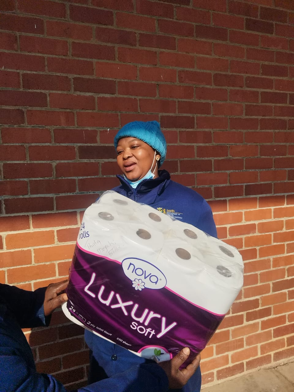 Customer receiving a 24-roll Nova Luxury Soft 2-ply tissue pack