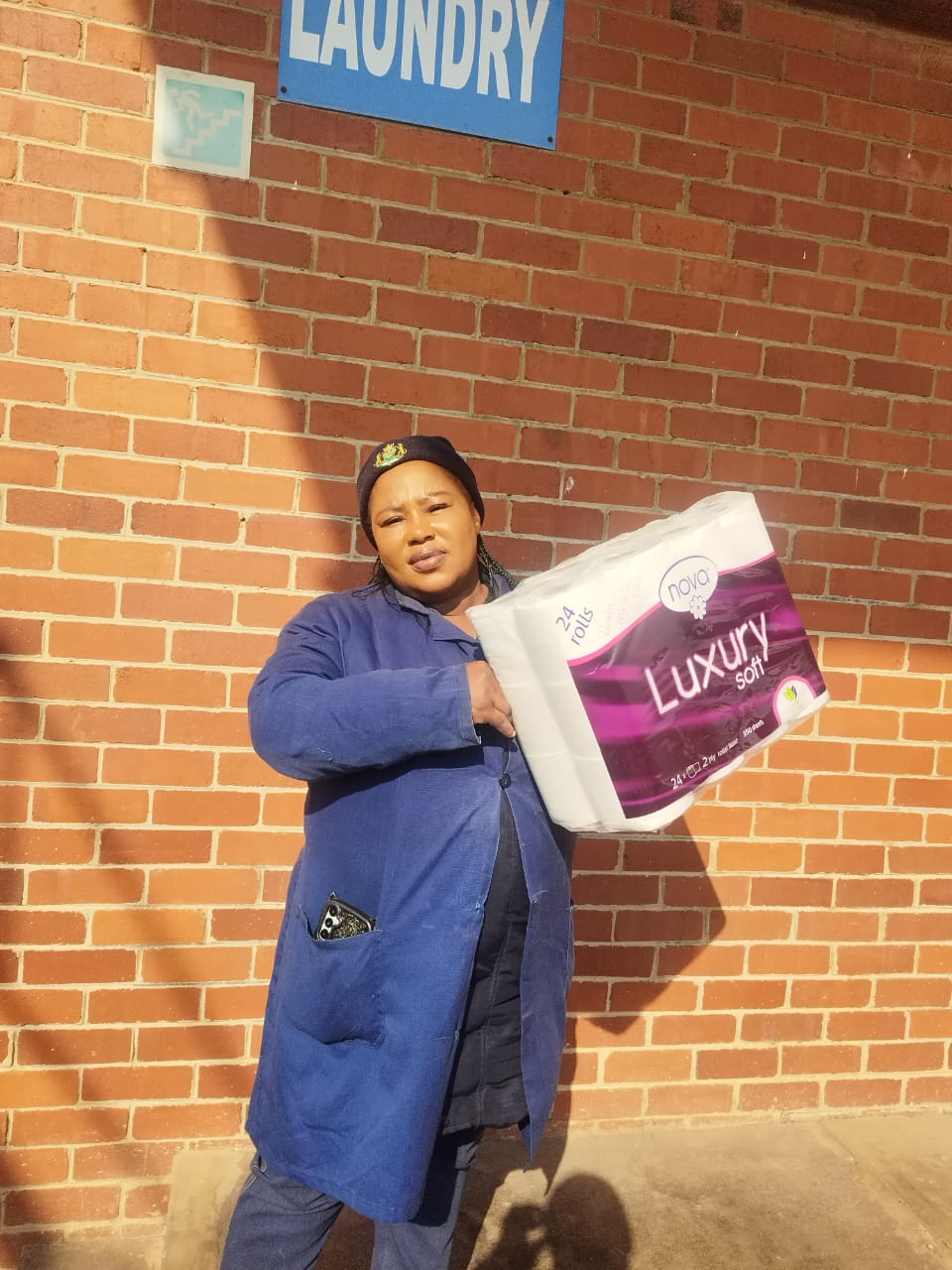 Happy customer collecting a 24-roll Nova Luxury Soft tissue pack